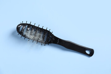 Brush with lost hair on light blue background