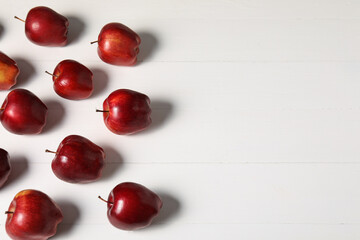 Fresh red apples on white wooden table, flat lay. Space for text