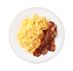 Delicious scrambled eggs with bacon on plate isolated on white, top view
