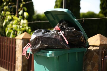 Trash bags full of garbage in bin outdoors