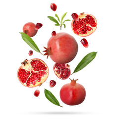 Fresh pomegranates, seeds and leaves in air on white background
