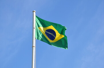 Flag of Brazil fluttering in the wind. In the center of the flag with the words 