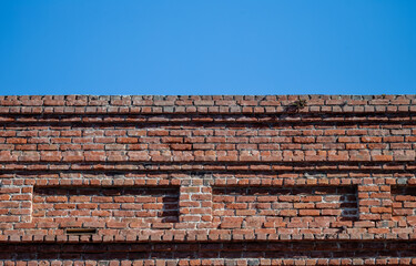 Vintage Red Brick Building Wall Under Blue Sky.