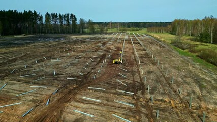 Deforested land with solar panel field setup in progress, aerial
