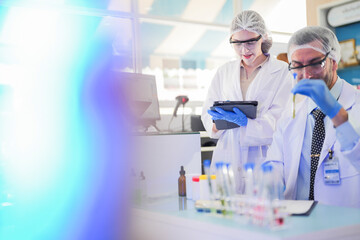 scientists perform experiments and record data. people arranges equipment with test tubes and chemicals for producing medicine and biochemistry. man hold tubes of chemical liquids and plant samples.