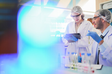 scientists perform experiments and record data. people arranges equipment with test tubes and chemicals for producing medicine and biochemistry. man hold tubes of chemical liquids and plant samples.