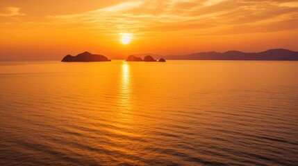 Naklejka premium Stunning Sunset Over Calm Ocean with Silhouetted Islands and Vibrant Orange Sky