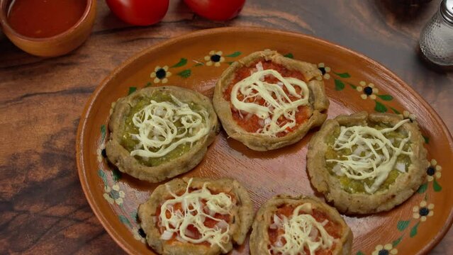 Mexican cuisine, Corn dough bites green and red sauce with string cheese, sopes