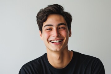Fototapeta premium Portrait of a smiling young man isolated on a gray background.