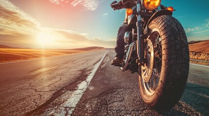 Close-up shot of a motorbike rider on the road with empty space around him and a background of desert and blue sky. Capturing the thrill of the ride in an open, expansive landscape