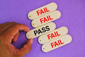 sticks with the words pass and fail. hand choose pass. the concept of testing or talent. inspection concept