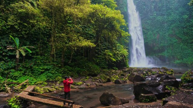 Travel people explore hidden gem Bali amazing Nungnung waterfall located over an hour from touristy town Ubud Bali Indonesia 4K Aerial