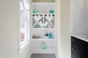 Elegant Built-In Shelves Decorated With Towels And Glassware By A Bright Window