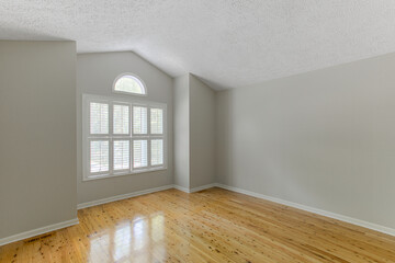 Modern Bright Empty Room With Wooden Flooring And A Window Allowing Natural Light