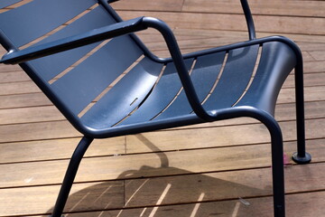 A lounge chair stands on the sidewalk on a street in a big city.