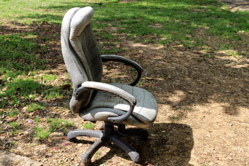 A lounge chair stands on the sidewalk on a street in a big city.
