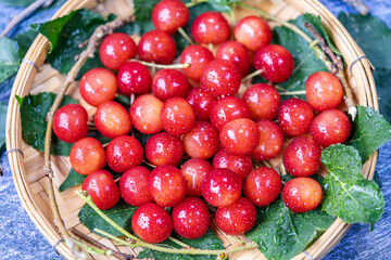 Red Cherry fruit in bamboo basket on on wooden background, Japanese Red highest variety of cherries on wooden table.