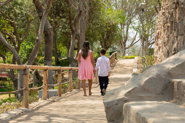 Family members holding hands while walking in a park during a sunny day in Lima Peru