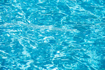 Ripple Water in swimming pool with sun reflection. Wavy water background.