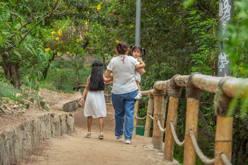 Family members holding hands while walking in a park during a sunny day in Lima Peru