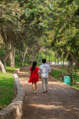Family members holding hands while walking in a park during a sunny day in Lima Peru
