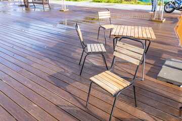 A wooden deck with a table and three chairs