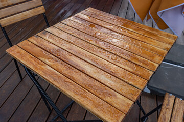 A wooden table with water droplets on it