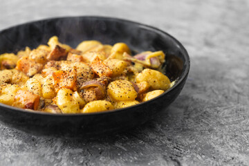 turmeric gnocchi with pumpkin and onion in creamy sauce, healthy plant-based food