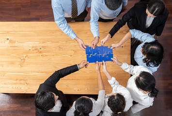 Multiethnic business people holding jigsaw pieces and merge them together as effective solution...