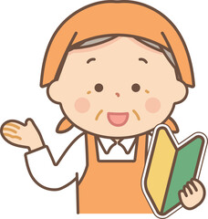 初心者マークを持って説明をするエプロン姿のシニア女性