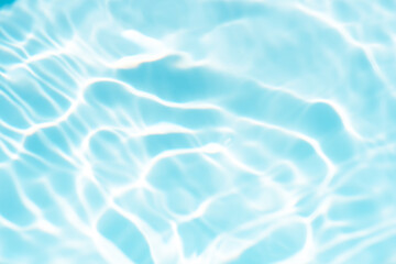 Blue water with ripples on the surface. Defocus blurred transparent blue colored clear calm water surface texture with splashes and bubbles. Water waves with shining pattern texture background.