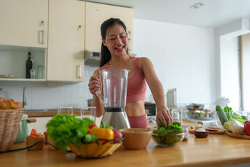 Woman making smoothie with blender and bowl of vegetables Green leafy fruits that are beneficial to health The concept of maintaining the body, taking care of it, healthy food. exercise.
