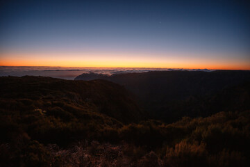 Hiking on the highest peak of Madeira Pico Ruivo next to the cottage Abrigo do Pico Ruivo. Views of the surrounding mountains lanscape during sunrise