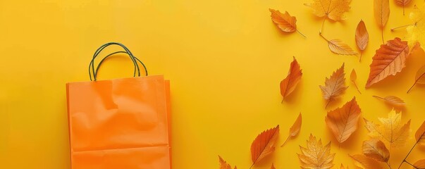A yellow background with a shopping bag and leaves. Free copy space for text.