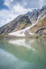 Obraz premium Blue mirror water of Panj river between Afghanistan and Tajikistan, river flows in a valley among rocky mountains in the Pamirs, panoramic landscape for background