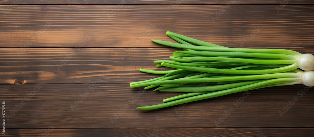 Aufkleber top-down view of vibrant green onion placed on a wooden table with space for a photo. with copy spac