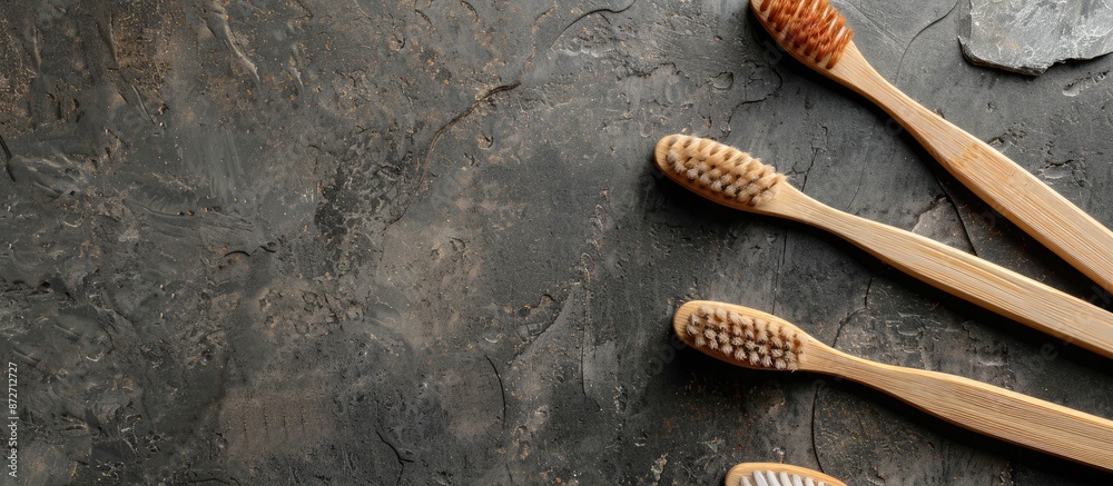 Poster biodegradable wooden toothbrushes made from eco-friendly bamboo, displayed on a gray stone backgroun