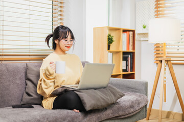 Woman working at home holding coffee cup in hand.