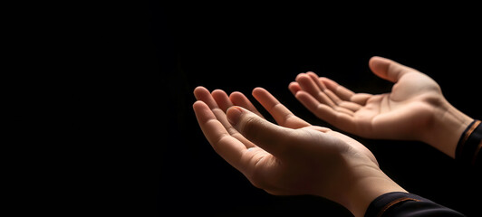 Fototapeta premium Praying Hands with White Embroidered Robe Against Dark Background