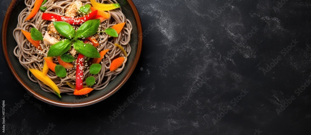 Poster top-down view of a grey bowl containing japanese buckwheat soba noodles with chicken, carrots, bell 