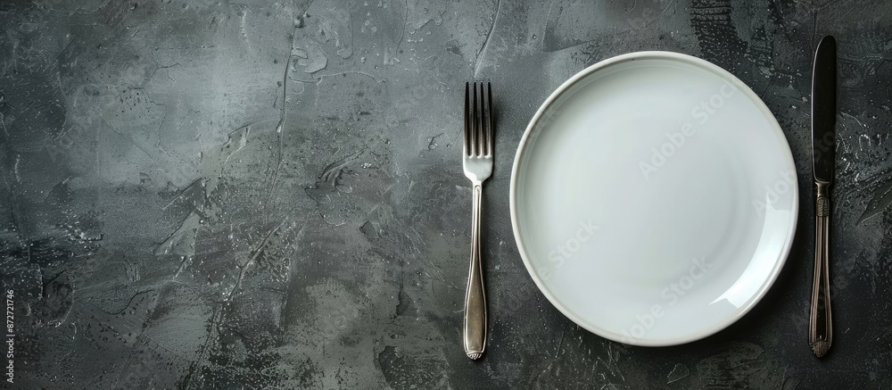 Poster gray stone concrete table with an empty white ceramic plate, knife, and fork. perfect for menu or re