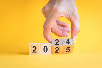 Hand flipping toy block, from 2024 to 2025. New year concept.