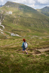 Naklejka premium Woman hiking in the mountains with backpack