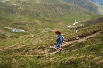 Fototapeta premium Woman hiking in the mountains with backpack