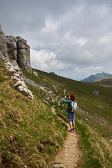 Fototapeta premium Woman hiking in the mountains with backpack