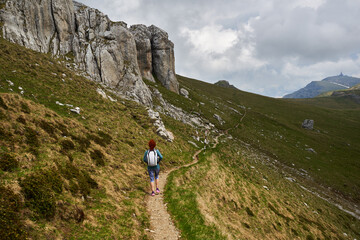 Fototapeta premium Woman hiking in the mountains with backpack
