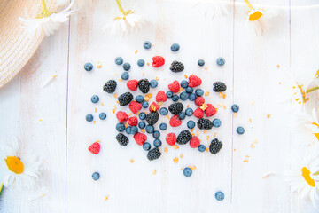 Wild Berries mix, raspberry, blueberry, blackberry, surrounded by daisies isolated