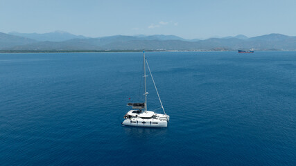 Obraz premium Aerial drone photo of beautiful catamaran sailing yacht anchored in tropical exotic turquoise sea exotic bay