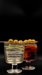 aperitivo con bebida de vermut con aceituna y hielos muy típica de españa
