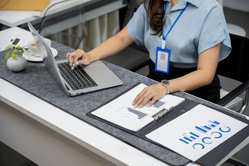 businesswoman or female assistant is working at her desk in the office, working on her laptop computer.
